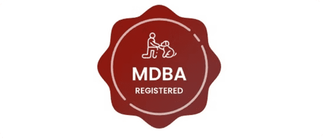 MDBA certification seal featuring dog trainer